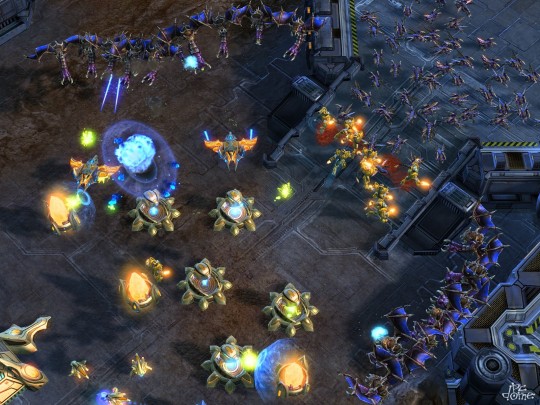Mutalisk és Zergling egységek támadnak egy Protoss bázisra